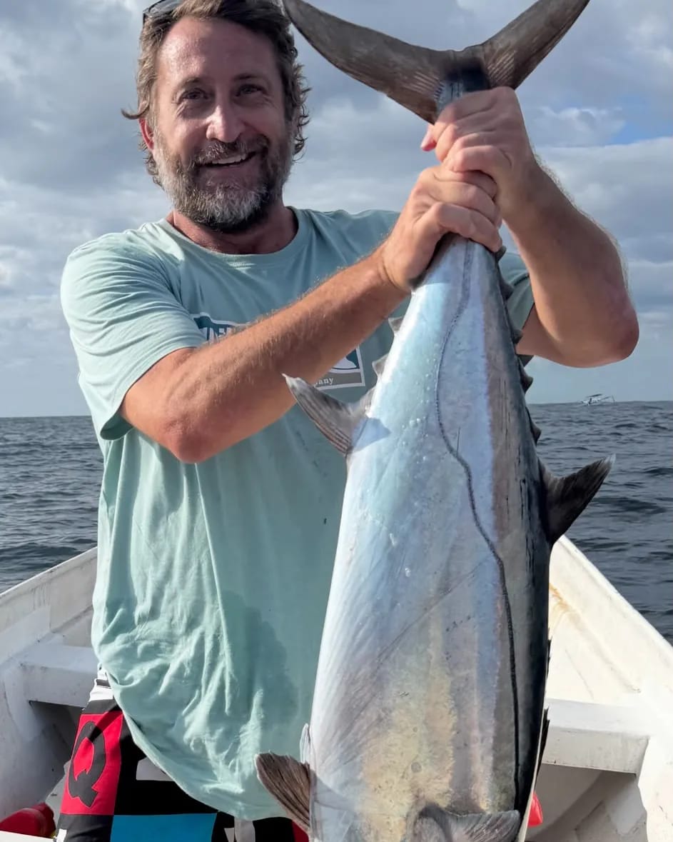 A crew member holding a tuna landed on the trip