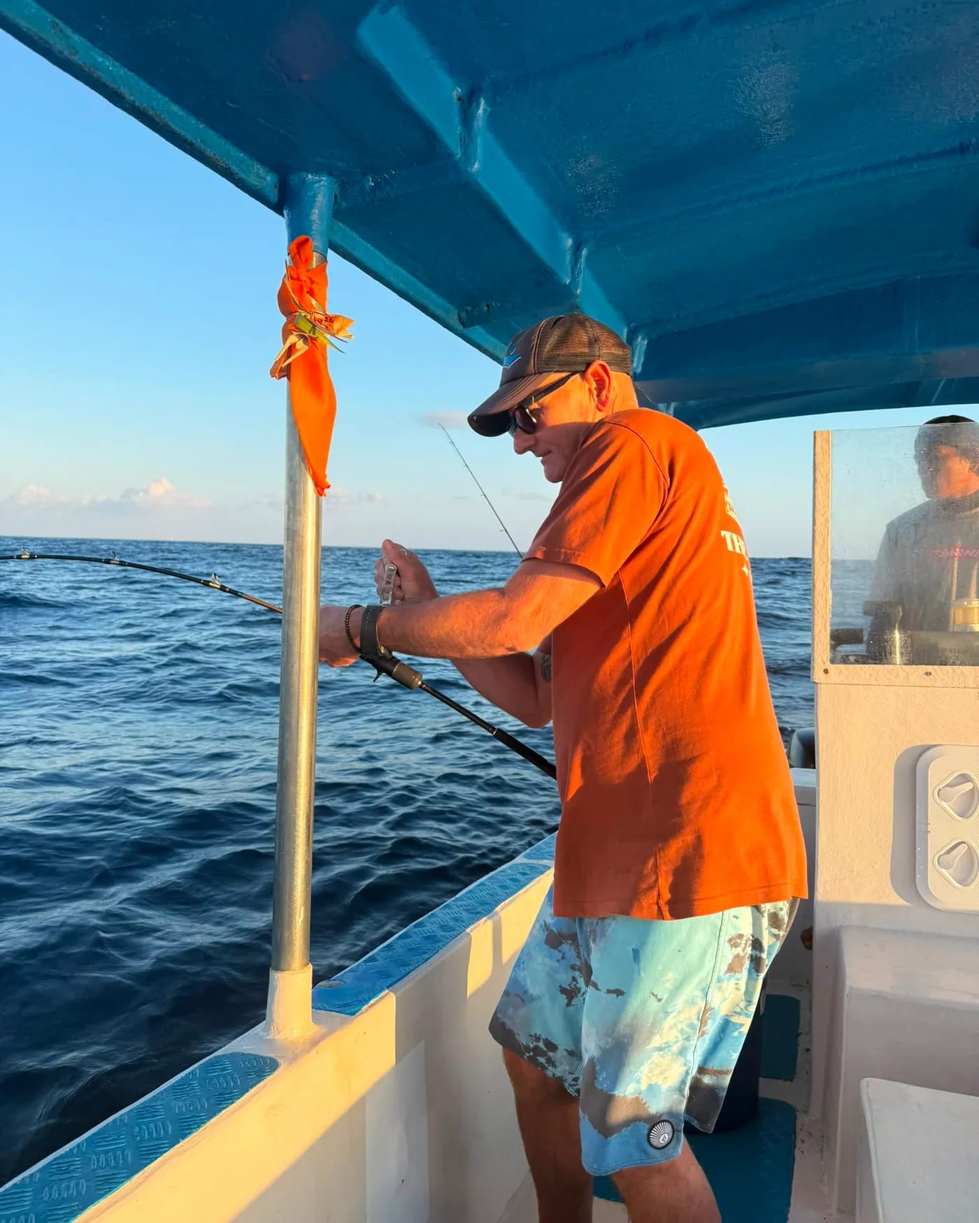 A guest working a rod as a fish runs offshore