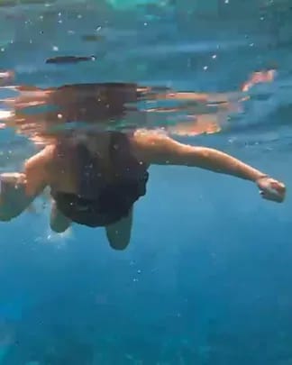 A snorkeller swimming in clear blue water