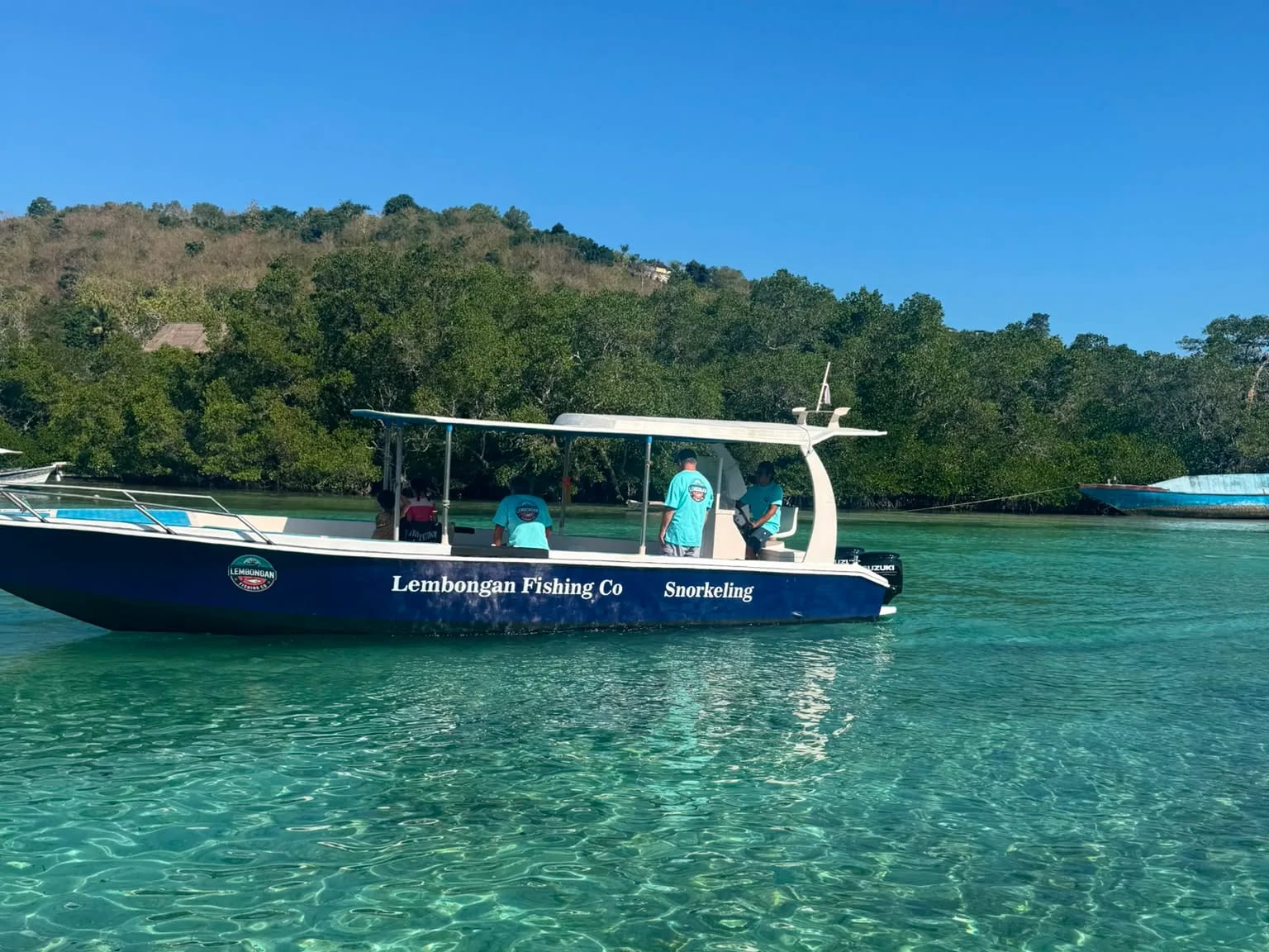 The Lembongan Fishing Co boat moored in clear shallow water off Nusa Lembongan